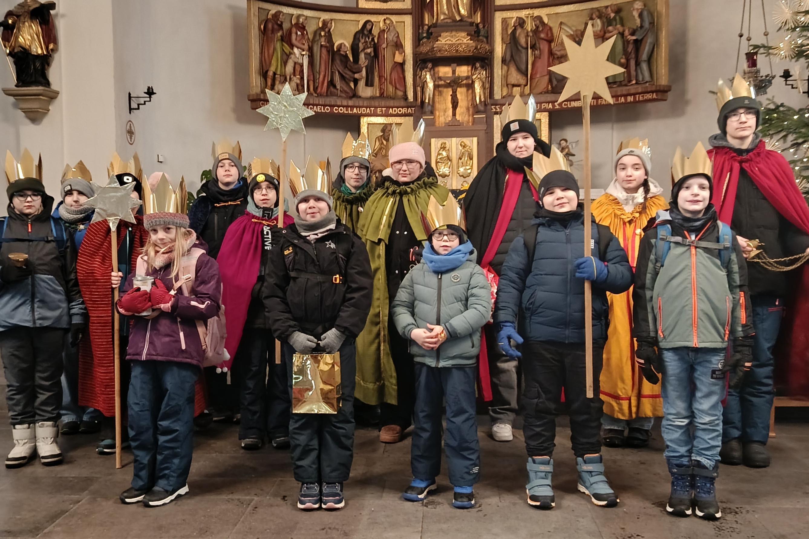 Kinder als Sternsinger am Altar