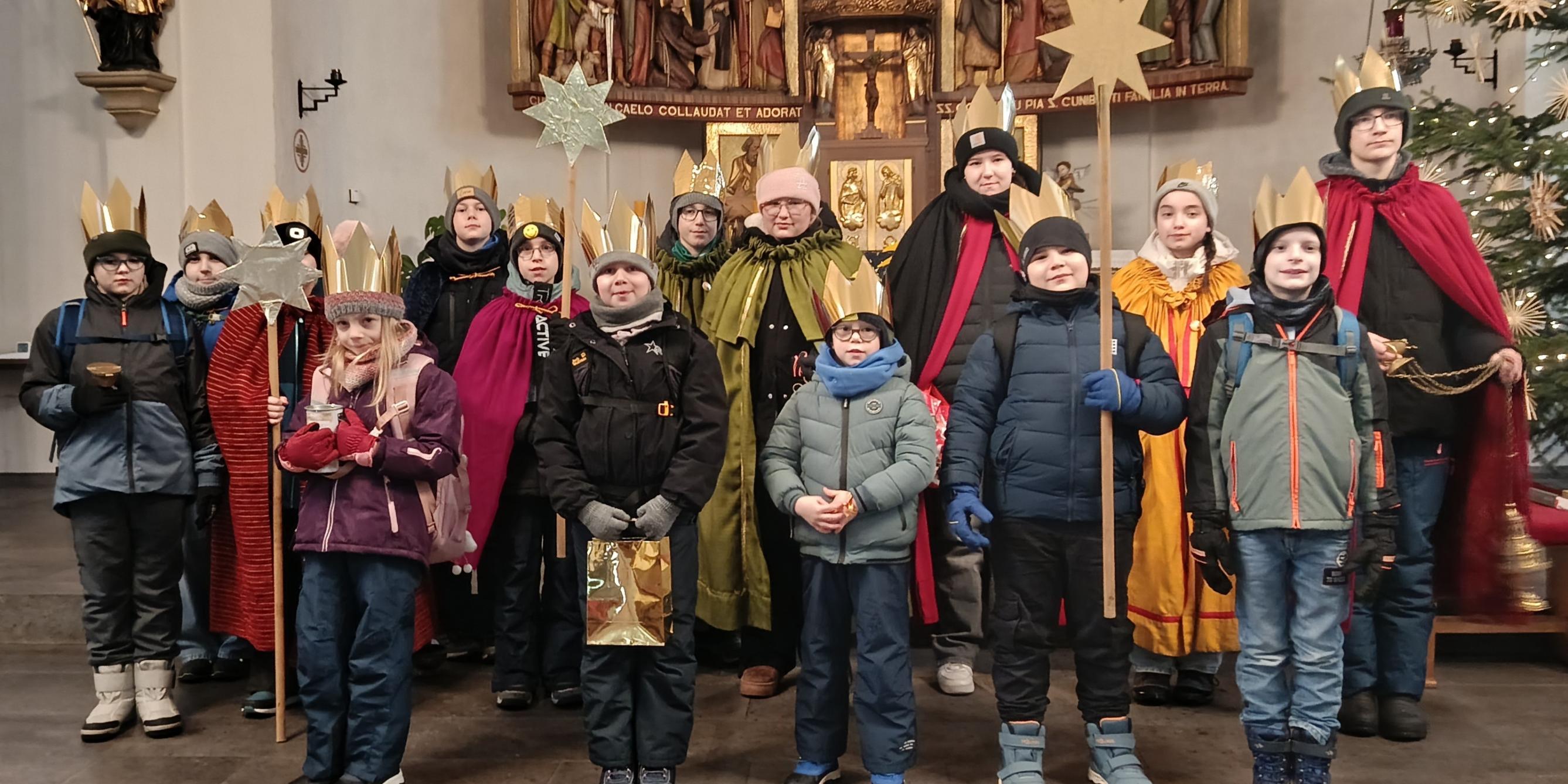 Kinder als Sternsinger am Altar